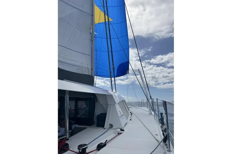 Slide: The Image of Sailing Catana 53 yacht with blue and yellow sails against a cloudy sky, 2021 model. - 14