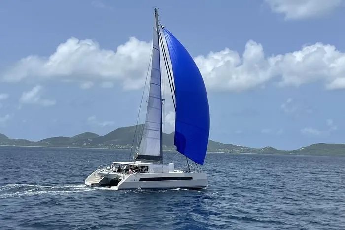 Slide: The Image of 2021 Catana 53 catamaran sailing with blue spinnaker on open sea. - 15