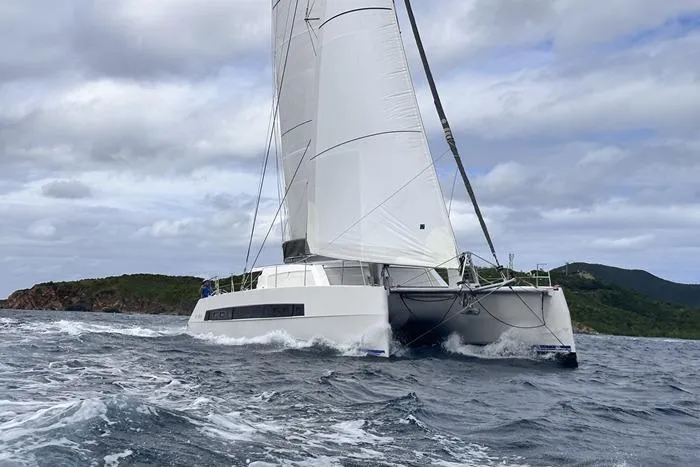 Slide: The Image of 2021 Catana 53 sailing catamaran navigating choppy waters under cloudy skies. - 16