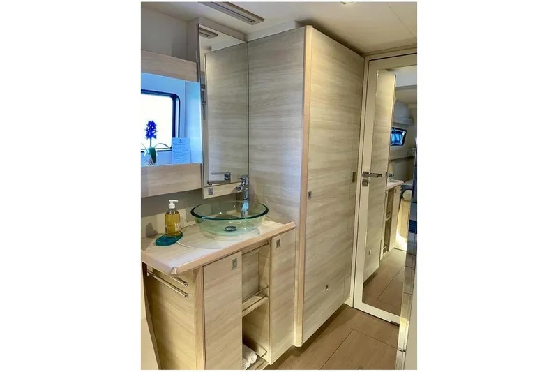 Slide: The Image of Modern bathroom interior on 2021 Catana 53 yacht with glass sink and wooden cabinetry. - 26