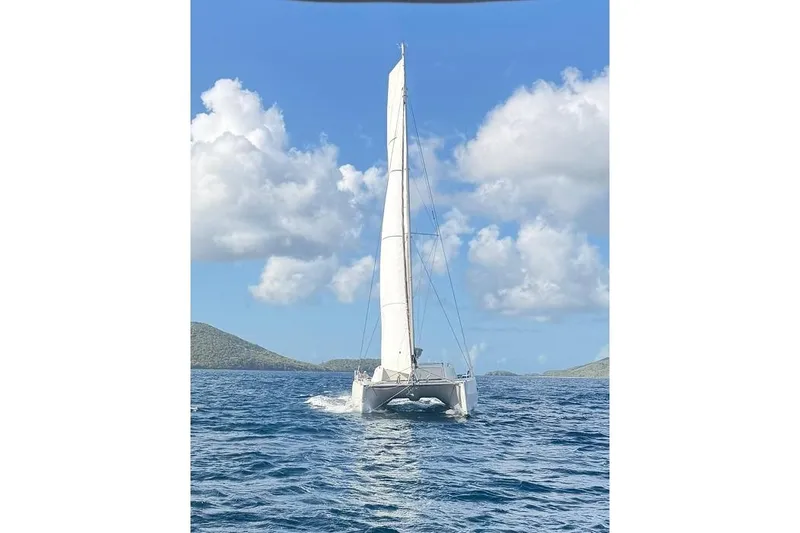 Slide: The Image of 2021 Catana 53 sailing catamaran on open sea under clear blue sky. - 3