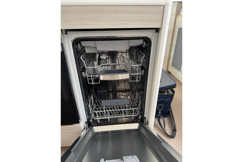 Slide: The Image of Open dishwasher inside a 2021 Catana 53 yacht kitchen. - 49