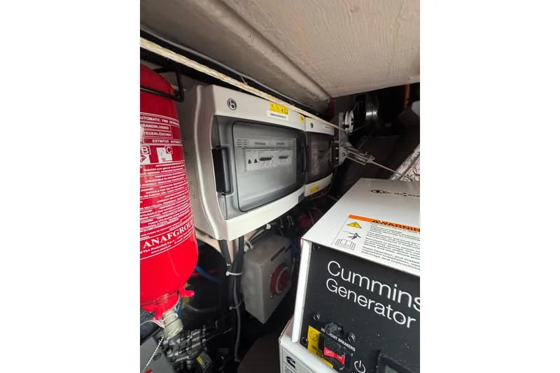 Slide: The Image of Engine room of 2021 Catana 53 with Cummins generator and fire extinguisher. - 61