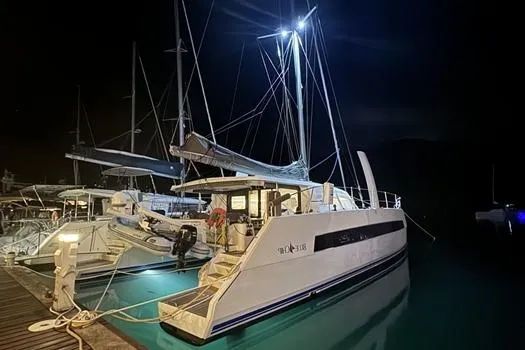 Slide: The Image of 2021 Catana 53 catamaran docked at night, illuminated by bright lights. - 7