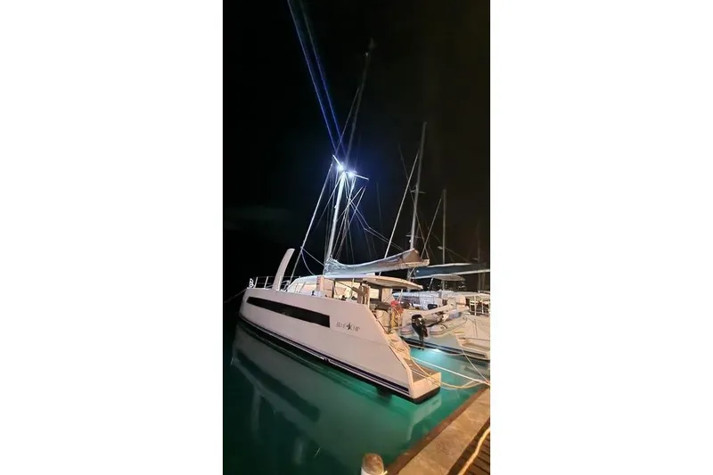 Slide: The Image of 2021 Catana 53 yacht docked at night, illuminated by bright lights. - 8