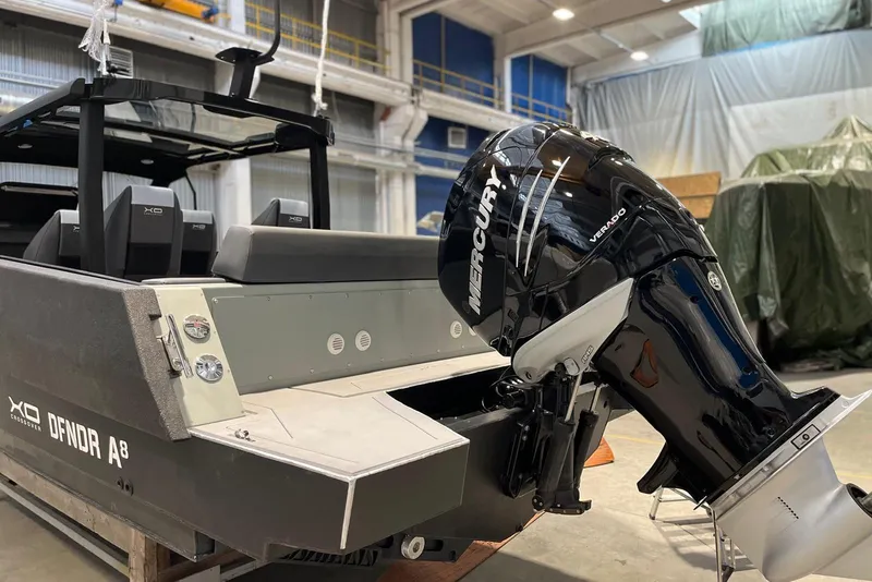 Slide: The Image of 2026 XO DFNDR A8 boat with Mercury Verado engine in a warehouse setting. - 10