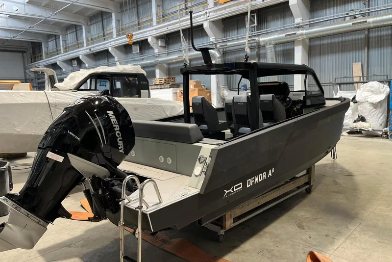 Slide: The Image of 2026 XO DFNDR A8 boat in a warehouse, featuring a Mercury Verado engine. - 11