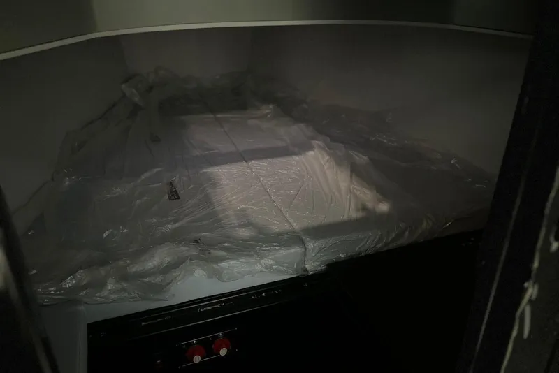 Slide: The Image of Interior of 2026 XO DFNDR A8, featuring a covered storage area with protective plastic. - 17