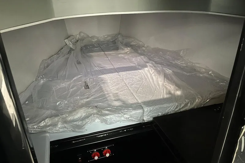 Slide: The Image of Interior of 2026 XO DFNDR A8, featuring a covered storage area with protective plastic. - 18