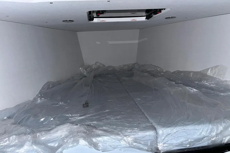 Slide: The Image of Interior of 2026 XO DFNDR A8 with plastic-covered mattress in a compact space. - 22