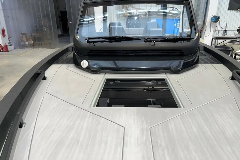Slide: The Image of 2026 XO DFNDR A8 boat interior with sleek design and modern features in a workshop setting. - 28