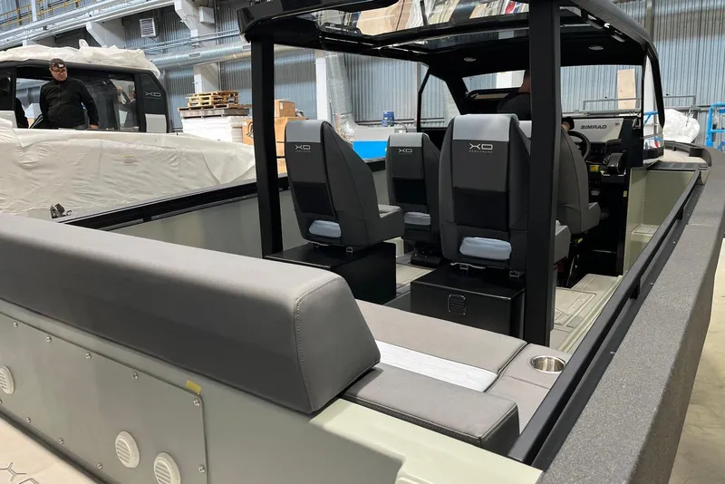 Slide: The Image of 2026 XO DFNDR A8 boat interior with modern seating and navigation equipment in a warehouse setting. - 3