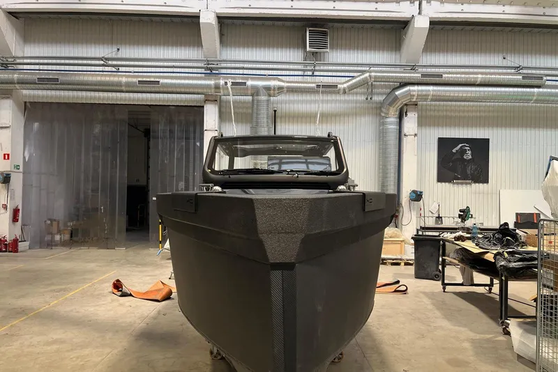 Slide: The Image of 2026 XO DFNDR A8 boat in a workshop, showcasing its sleek design and robust build. - 7