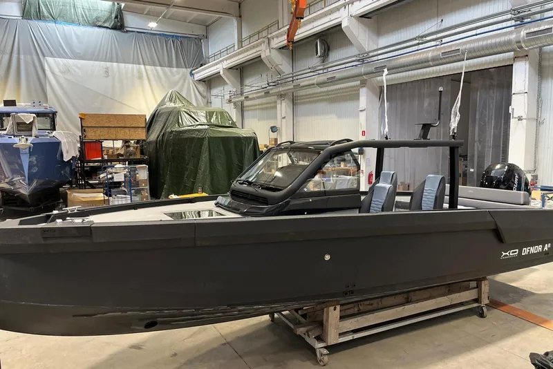 Slide: The Image of 2026 XO DFNDR A8 boat in a workshop, showcasing sleek design and modern features. - 9