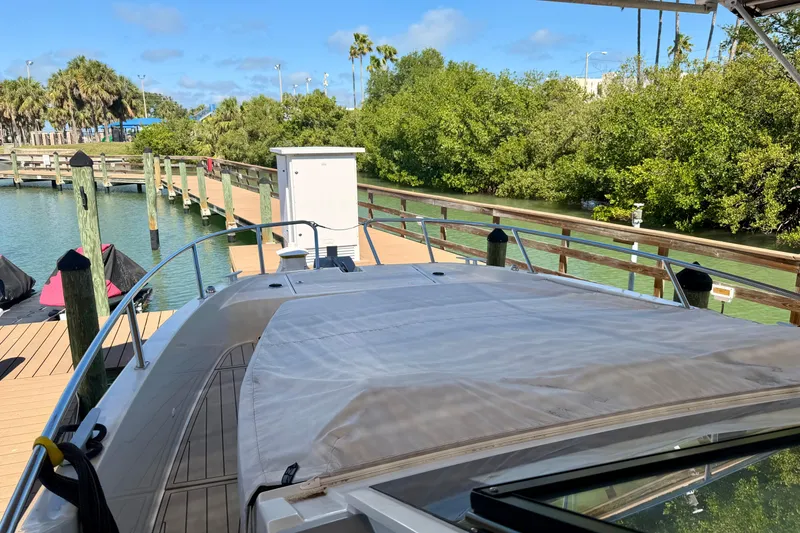 Slide: The Image of 2024 Beneteau Gran Turismo 32 docked at a scenic marina with lush greenery. - 16