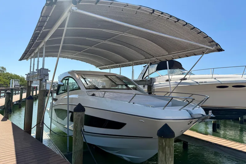 Slide: The Image of 2024 Beneteau Gran Turismo 32 docked under a canopy at a marina. - 17