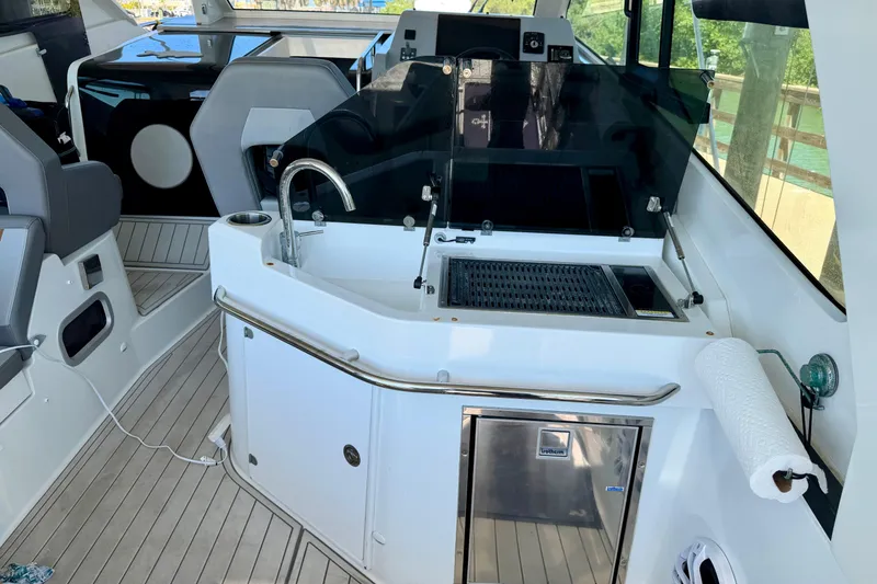 Slide: The Image of Interior view of 2024 Beneteau Gran Turismo 32 yacht, featuring a sleek kitchenette and seating area. - 18