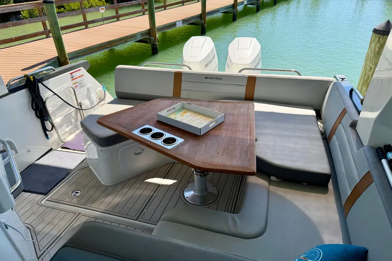 Slide: The Image of 2024 Beneteau Gran Turismo 32 yacht interior with seating and wooden table by the water. - 19