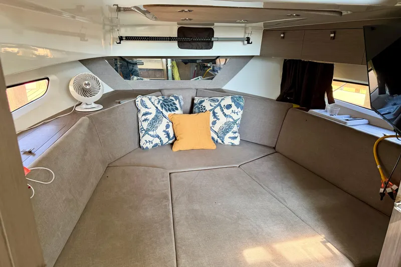 Slide: The Image of Interior cabin of 2024 Beneteau Gran Turismo 32 with cozy seating and decorative pillows. - 24