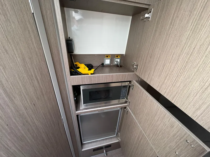 Slide: The Image of 2024 Beneteau Gran Turismo 32 kitchen area with microwave and storage cabinets. - 26