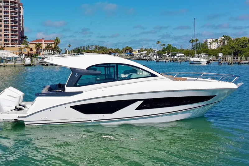 Slide: The Image of 2024 Beneteau Gran Turismo 32 yacht cruising in a sunny marina setting. - 39