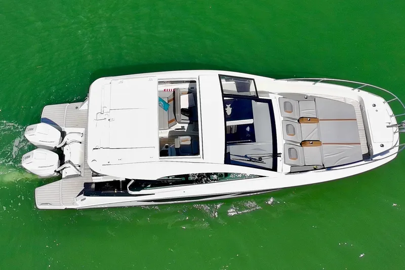 Slide: The Image of 2024 Beneteau Gran Turismo 32 yacht cruising on vibrant green water, aerial view. - 8
