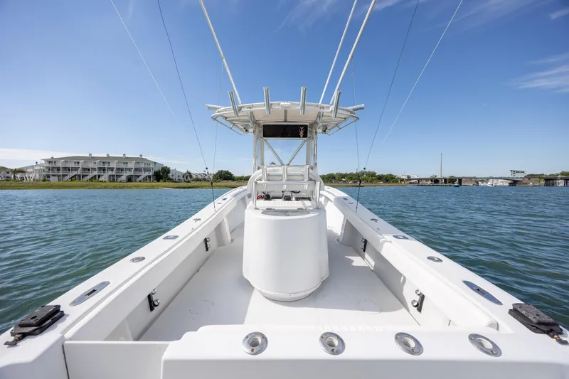 Slide: The Image of 2002 Yellowfin 31 Center Console boat on calm water, clear sky background. - 13