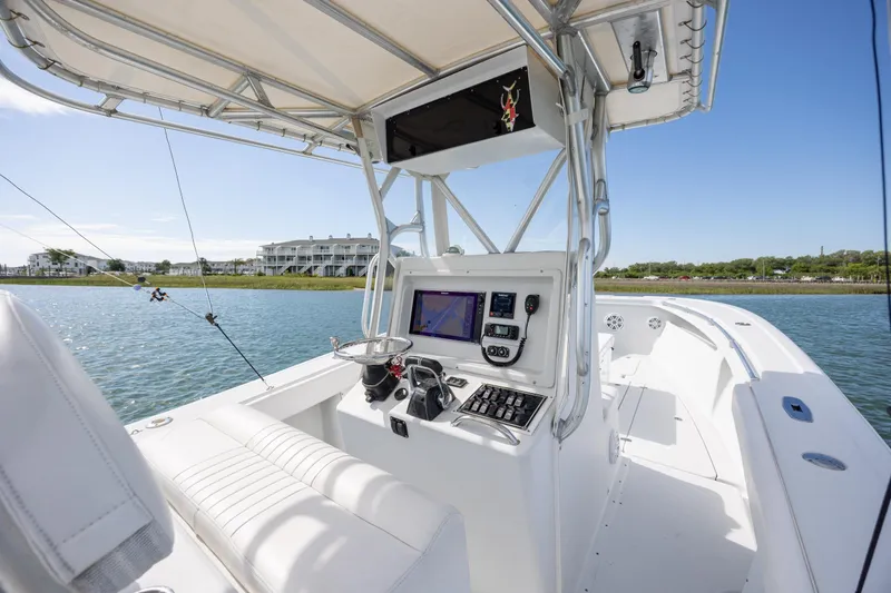 Slide: The Image of 2002 Yellowfin 31 Center Console boat interior with navigation equipment on calm water. - 16