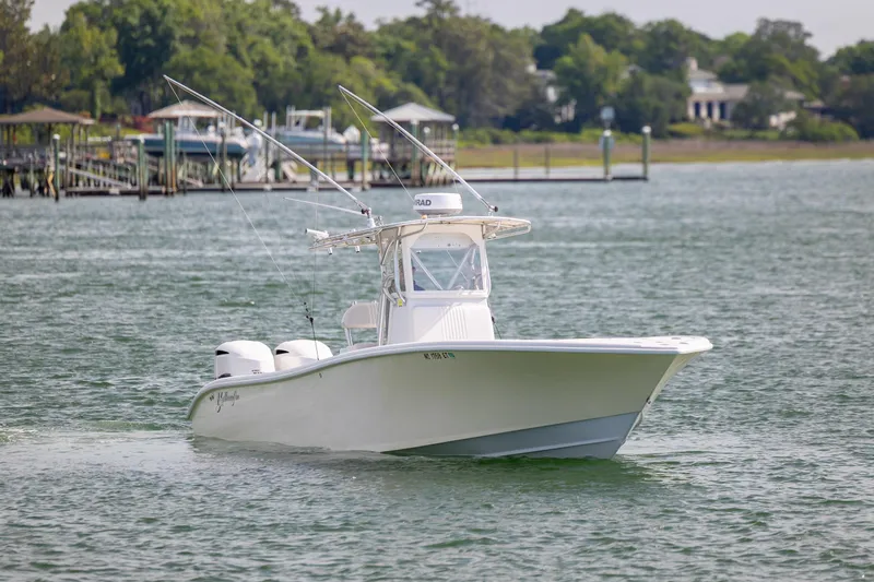 Slide: The Image of 2002 Yellowfin 31 Center Console boat cruising on a calm lake. - 2