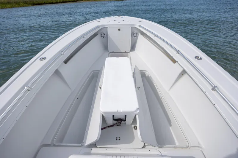 Slide: The Image of 2002 Yellowfin 31 Center Console boat interior with seating and storage on calm water. - 24