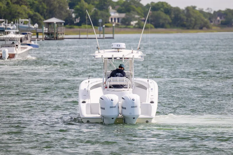 Slide: The Image of 2002 Yellowfin 31 Center Console boat cruising on a scenic waterway. - 7