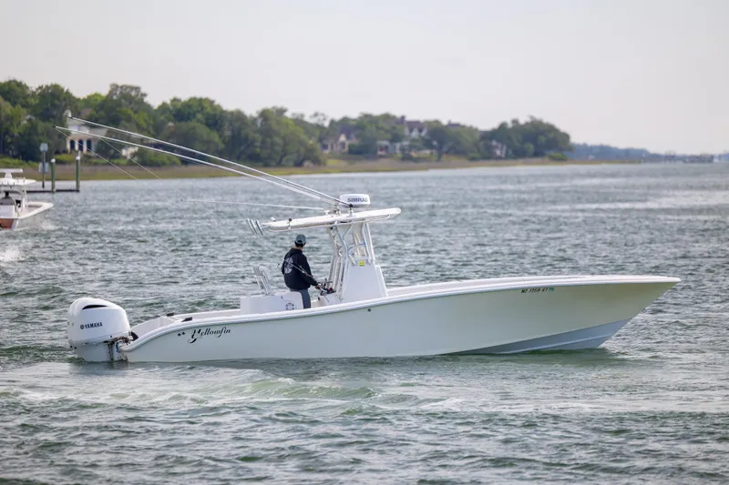 Slide: The Image of 2002 Yellowfin 31 Center Console boat cruising on a calm waterway. - 8