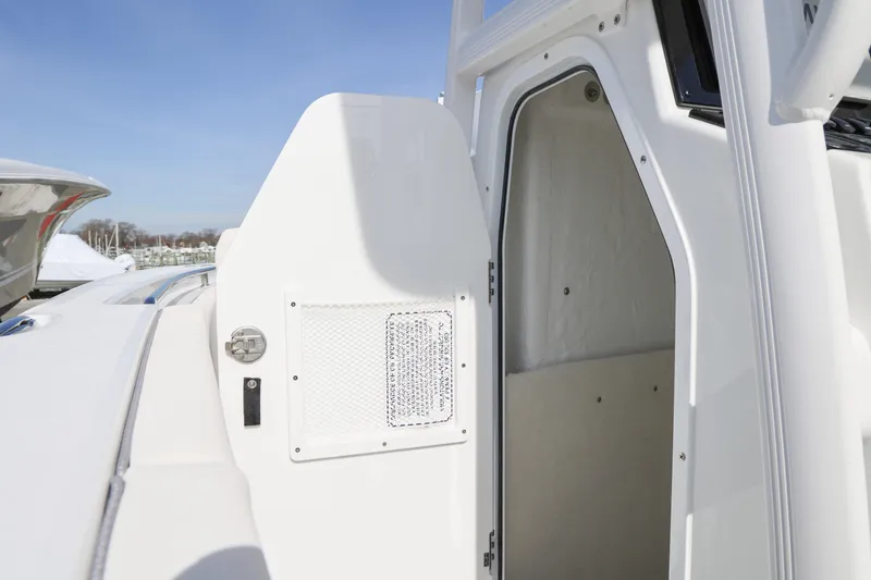 Slide: The Image of 2026 Sea Hunt Ultra 219 boat cabin entrance with open door under clear sky. - 11