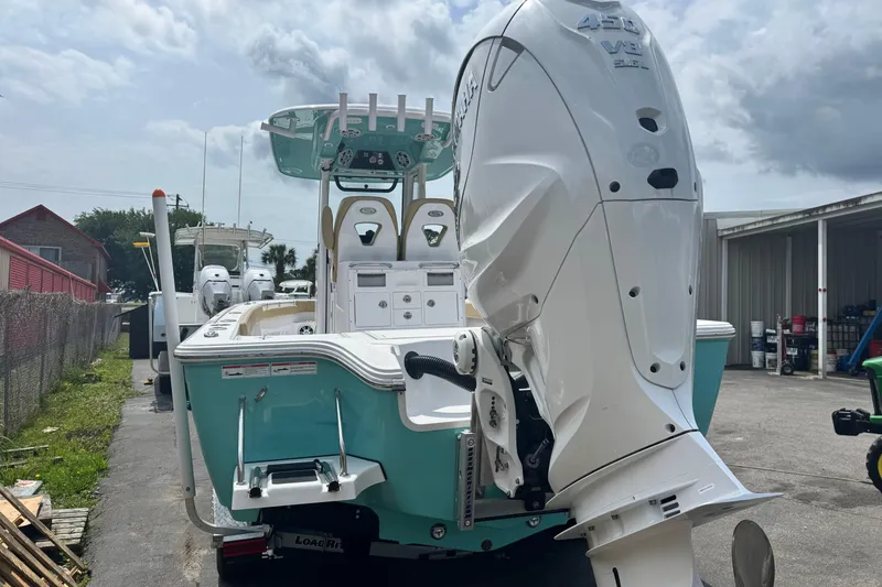 Slide: The Image of 2024 Sportsman Masters 267 Bay Boat with powerful outboard motor, parked outdoors. - 11