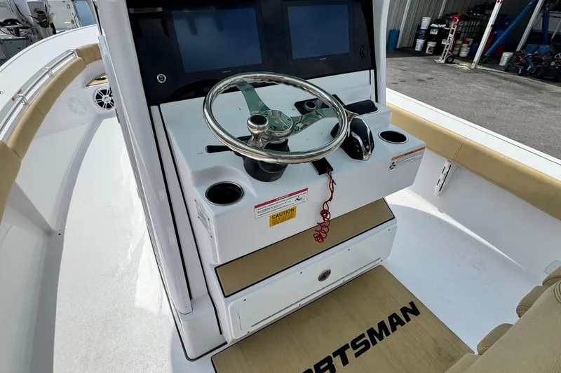Slide: The Image of 2024 Sportsman Masters 267 Bay Boat helm with steering wheel and dual screens. - 13