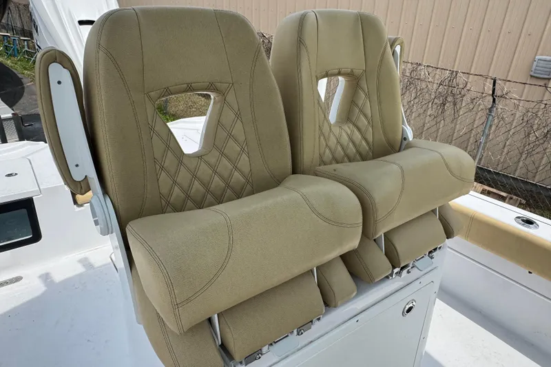 Slide: The Image of 2024 Sportsman Masters 267 Bay Boat seats with beige upholstery and diamond stitching. - 14