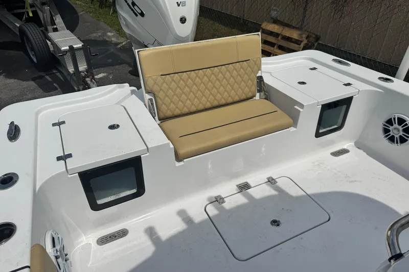Slide: The Image of 2024 Sportsman Masters 267 Bay Boat interior with tan seating and storage compartments. - 15