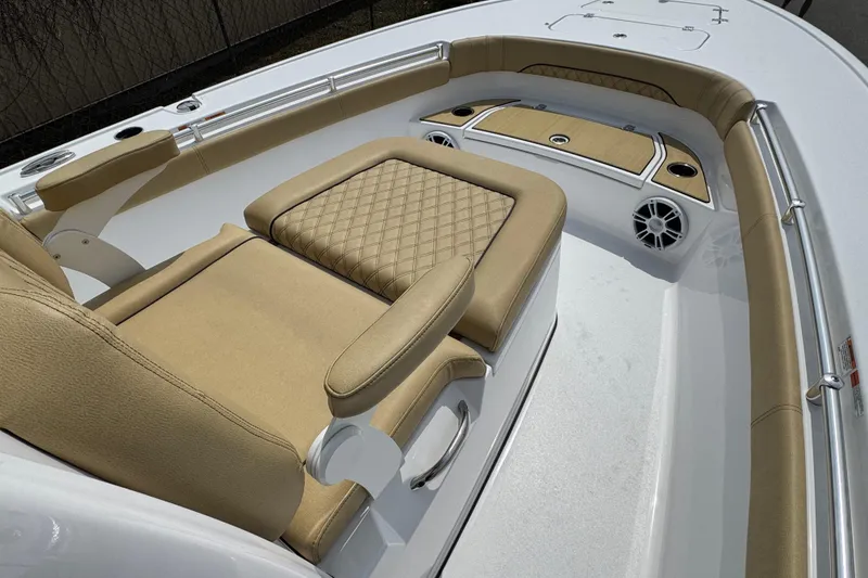 Slide: The Image of 2024 Sportsman Masters 267 Bay Boat interior with tan cushioned seating and storage compartments. - 18