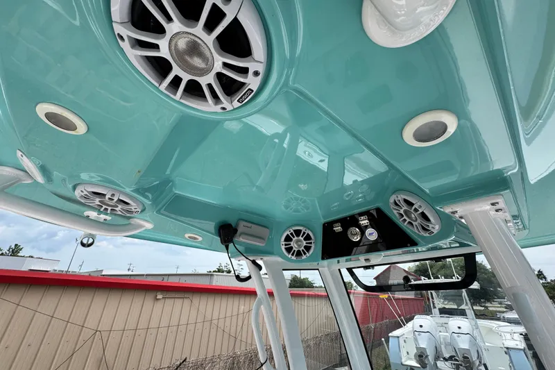 Slide: The Image of 2024 Sportsman Masters 267 Bay Boat interior with teal ceiling and integrated speakers. - 20