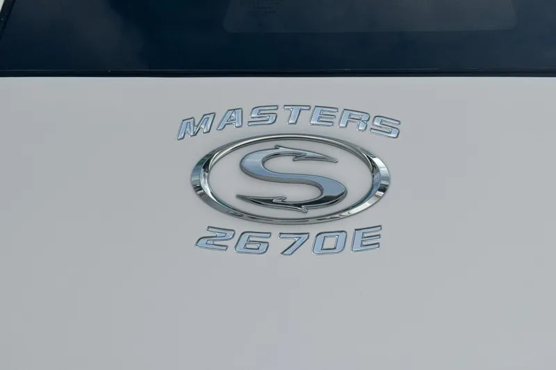 Slide: The Image of 2024 Sportsman Masters 267 Bay Boat emblem on white surface. - 21