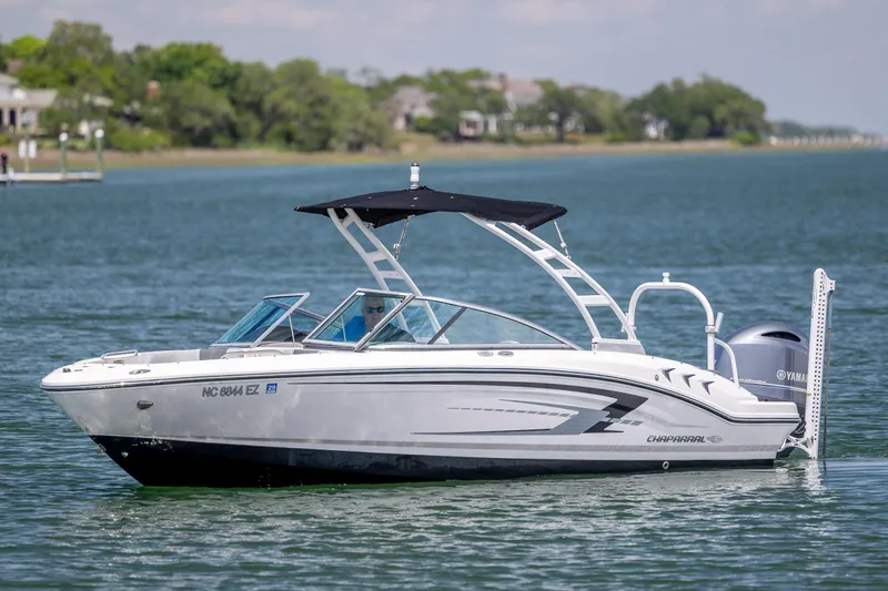 The Image of 2023 Chaparral 21 SSi boat on calm water with scenic background. - 1
