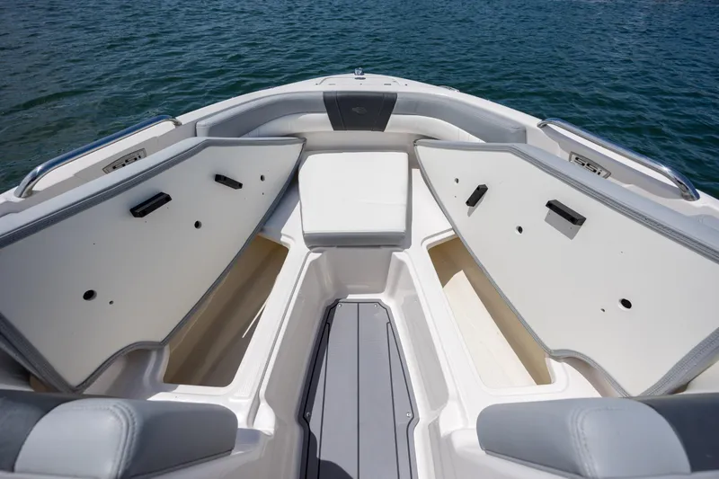 Slide: The Image of 2023 Chaparral 21 SSi boat interior with open storage compartments on calm water. - 10