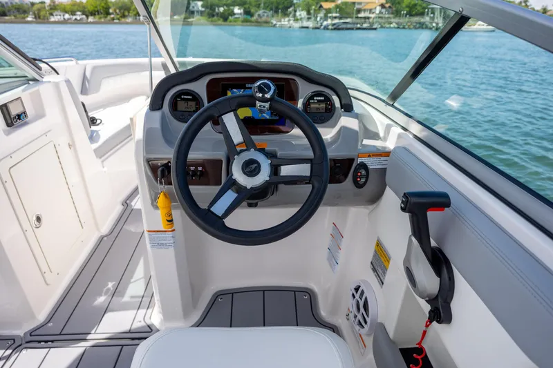 Slide: The Image of 2023 Chaparral 21 SSi boat cockpit with steering wheel and control panel on a sunny day. - 17