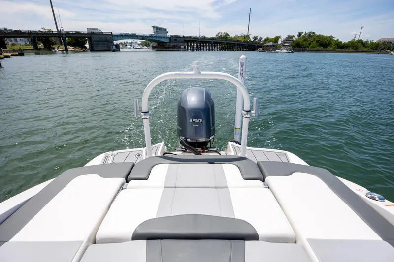 Slide: The Image of 2023 Chaparral 21 SSi boat with outboard motor on a sunny day near a bridge. - 22