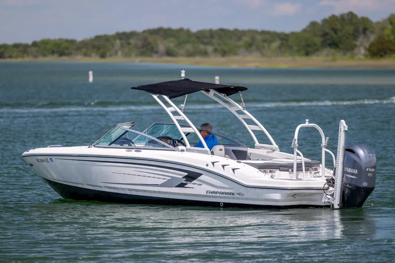 Slide: The Image of 2023 Chaparral 21 SSi boat cruising on a lake with Yamaha outboard motor. - 3