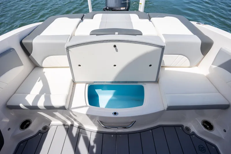 Slide: The Image of 2023 Chaparral 21 SSi boat interior with open storage compartment, white and gray seating. - 6