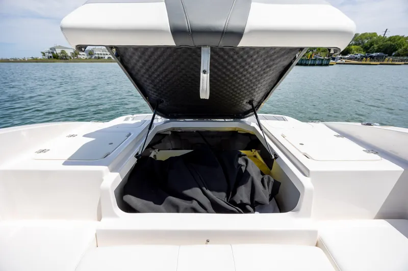Slide: The Image of 2023 Chaparral 21 SSi boat with open storage compartment on a sunny day. - 7
