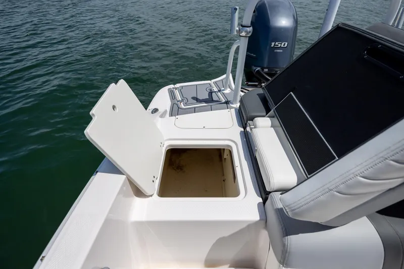 Slide: The Image of 2023 Chaparral 21 SSi boat with open storage compartment and Yamaha 150 engine. - 9
