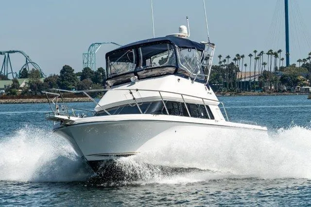 Slide: The Image of Skipjack 300 Flybridge 2011 cruising on water with scenic background. - 13