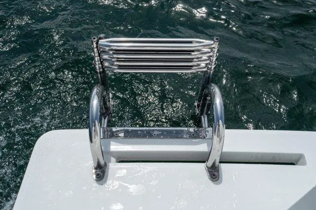 Slide: The Image of Stainless steel boat ladder on 2011 Skipjack 300 Flybridge, over sparkling water. - 24